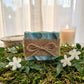 You will be generating high-quality product photos for an online stores product page. The product images should closely match the original products.
      Here is the prompt (IMPORTANT!): """A styled lifestyle scene capturing the soap embraced in a spa-lik