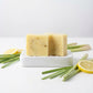 You will be generating high-quality product photos for an online stores product page. The product images should closely match the original products.
      Here is the prompt (IMPORTANT!): """A minimalistic editorial-style shot of Lemongrass Soap in a brigh