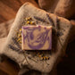 You will be generating high-quality product photos for an online stores product page. The product images should closely match the original products.
      Here is the prompt (IMPORTANT!): """An artistic, moody image of the soap lying on a rustic, textured 
