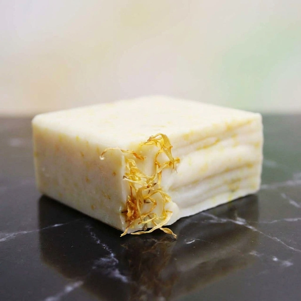 You will be generating high-quality product photos for an online stores product page. The product images should closely match the original products.
      Here is the prompt (IMPORTANT!): """A close-up shot of the Unscented Calendula Soap resting on a slee